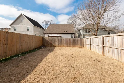 a view of a backyard with a wooden fence