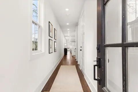 a view of a hallway with wooden floor and staircase