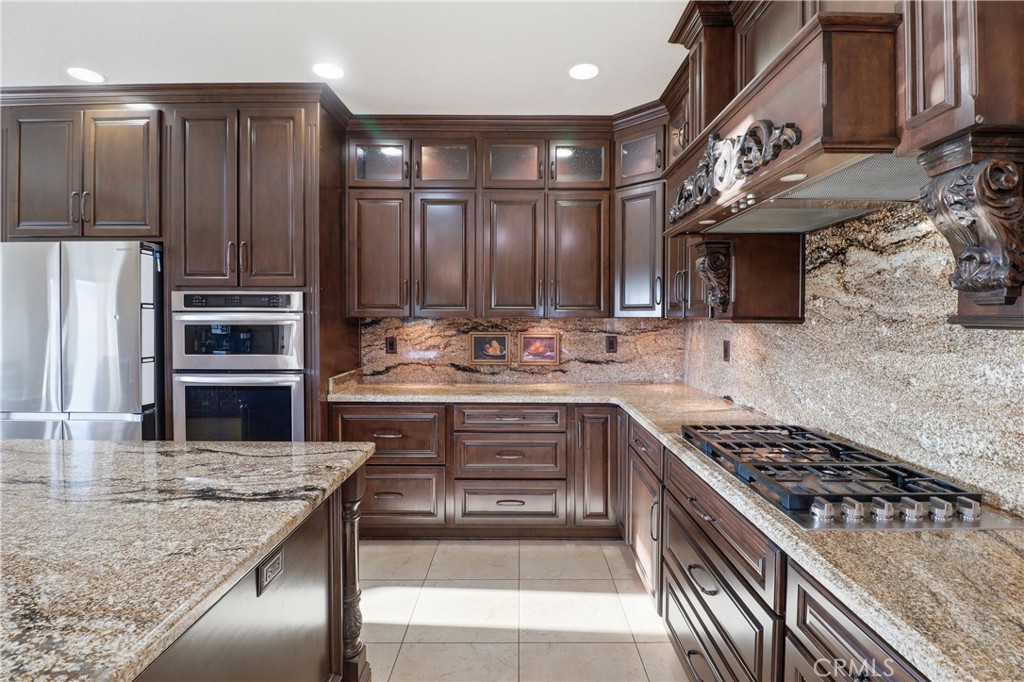 16025 Perry Heights Drive Riverside, CA 92504 - Photo 18 of 52 a kitchen with kitchen island stainless steel appliances a stove a sink and a refrigerator