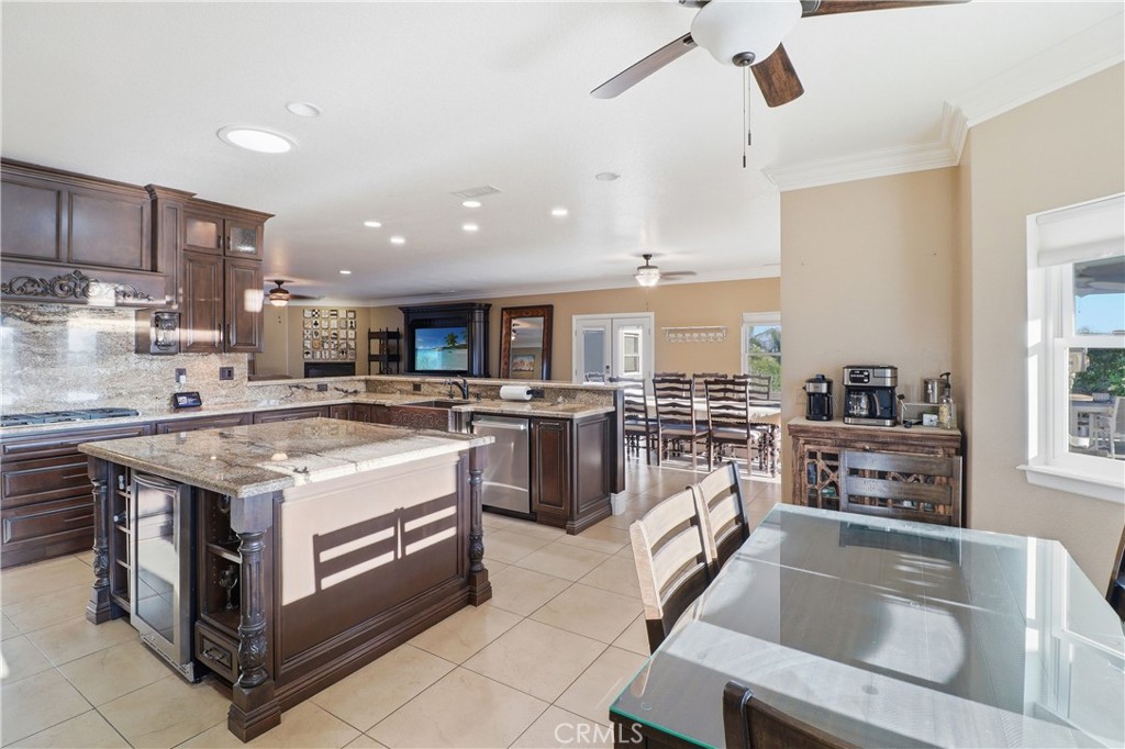 16025 Perry Heights Drive Riverside, CA 92504 - Photo 22 of 52 a kitchen with kitchen island a stove a sink a refrigerator and cabinets