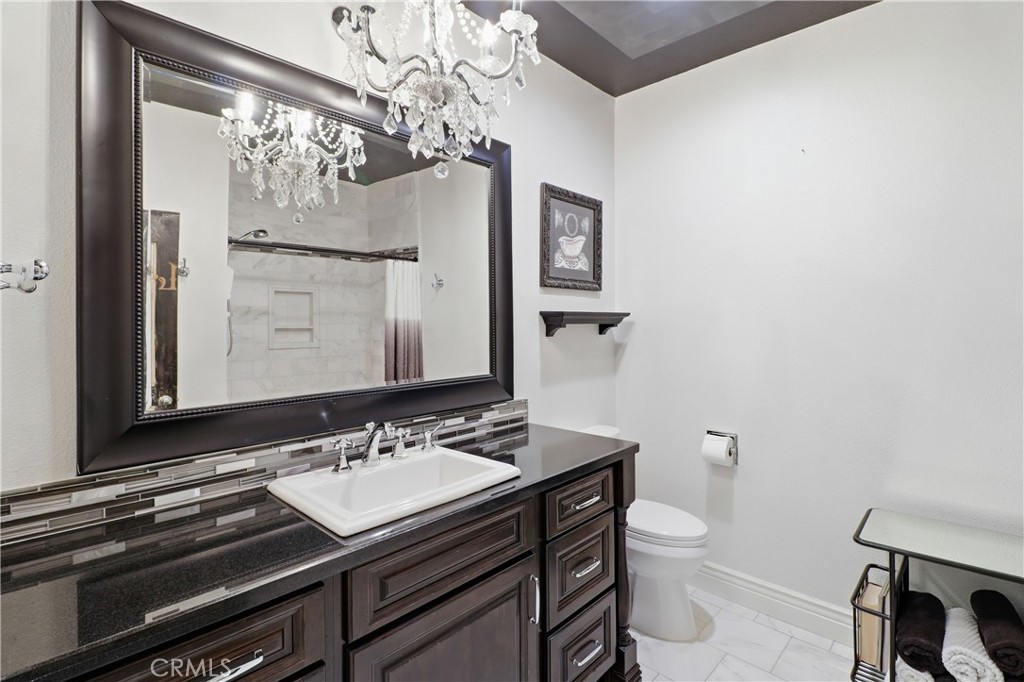 16025 Perry Heights Drive Riverside, CA 92504 - Photo 25 of 52 a bathroom with a toilet a sink and mirror