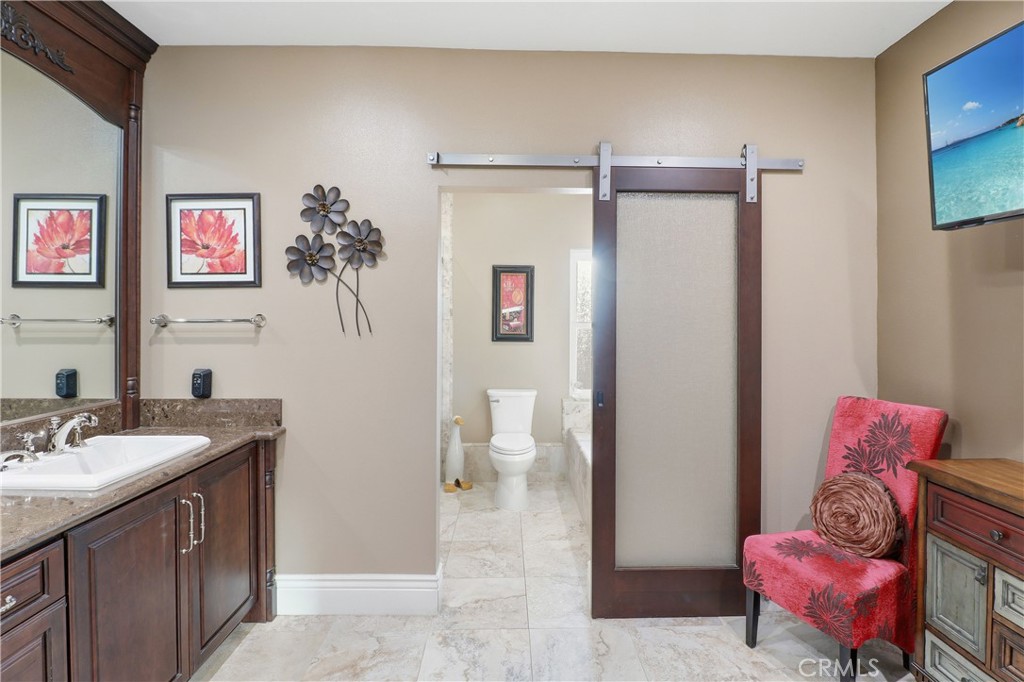16025 Perry Heights Drive Riverside, CA 92504 - Photo 37 of 52 a spacious bathroom with a sink mirror and toilet