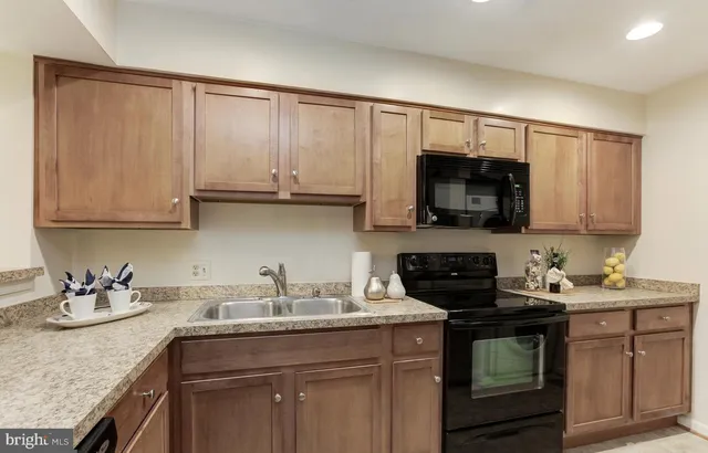 a kitchen with stainless steel appliances granite countertop a sink stove and microwave