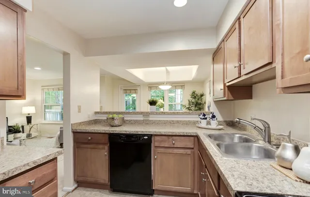 a kitchen with granite countertop kitchen island stainless steel appliances a sink stove and cabinets