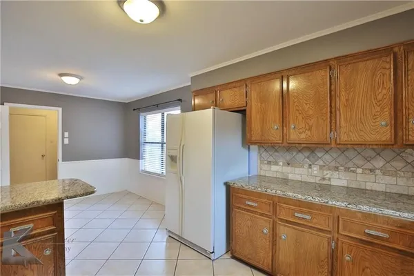 a kitchen with a refrigerator sink and cabinets