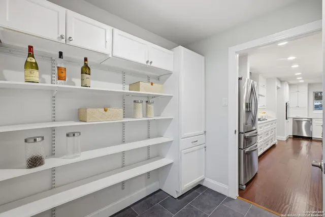 a kitchen with white cabinets and refrigerator