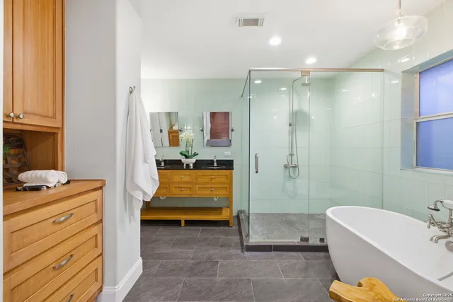 a bathroom with a tub a sink and mirror
