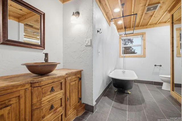 a bathroom with a sink a toilet and a mirror