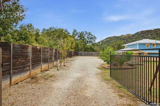 a view of roof deck with wooden fence and trees