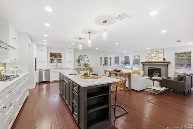 a large kitchen with stainless steel appliances a stove center island cabinets and a couch