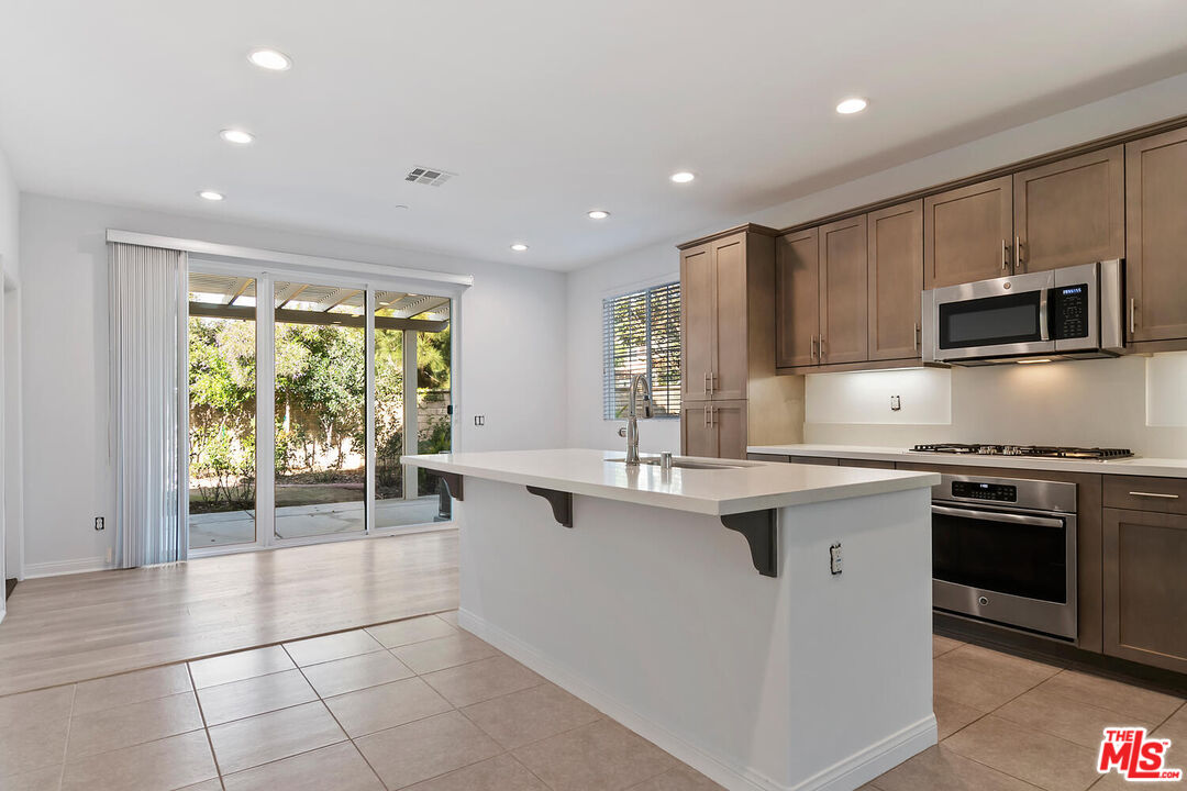 291 Santa Susana Road Camarillo, CA 93010 - Photo 6 of 32 a kitchen with stainless steel appliances granite countertop a stove top oven a sink a counter space and cabinets