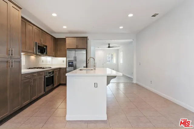 a kitchen with a sink stainless steel appliances and cabinets