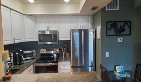 a kitchen with stainless steel appliances granite countertop a refrigerator and a stove top oven