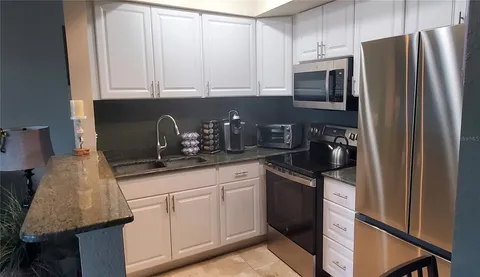 a kitchen with appliances a sink and cabinets