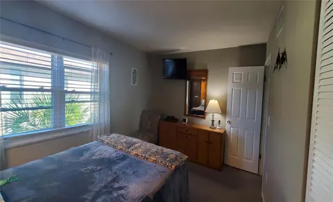 a bedroom with a bed and a dresser next to a window