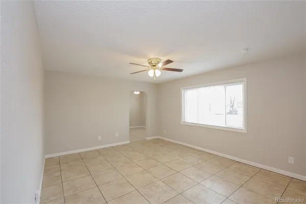 an empty room with windows and fan