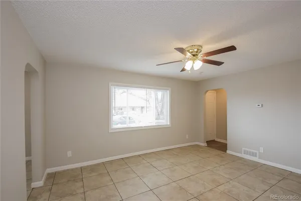 a view of an empty room with a ceiling fan and a window