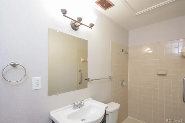 a bathroom with a toilet sink a mirror and vanity