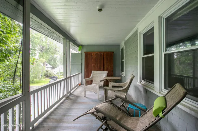 a view of an empty room with furniture and a window