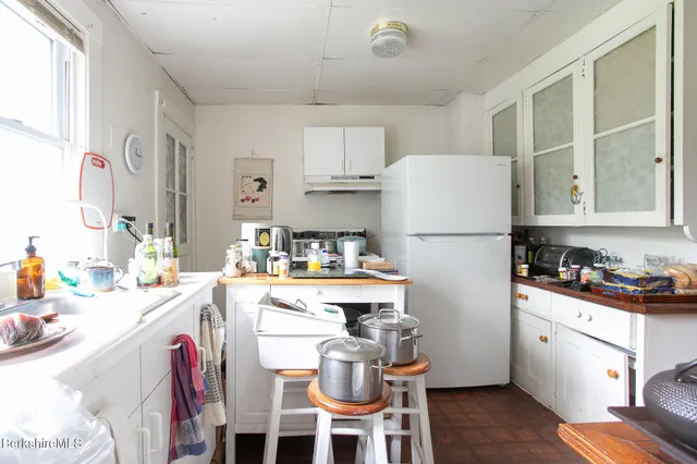 a bedroom with a bed and a flat tv screen on dresser