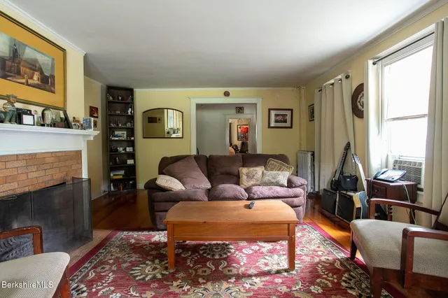 a kitchen with stainless steel appliances a stove a refrigerator white cabinets and wooden floor