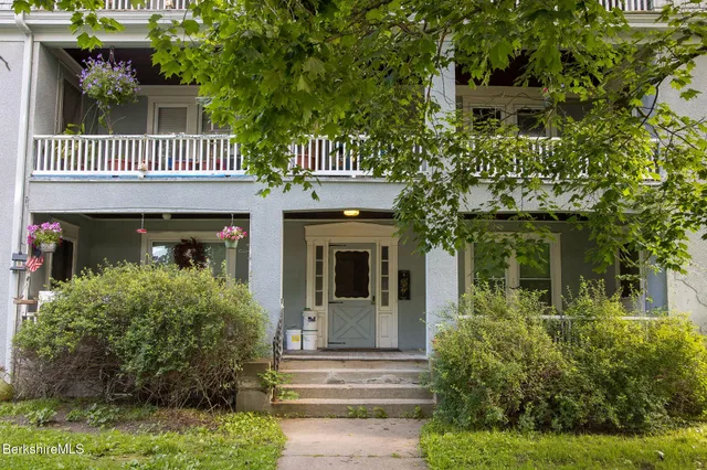 a view of a livingroom with wooden floor and furniture