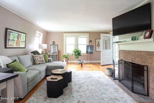a living room with furniture a fireplace and a flat screen tv