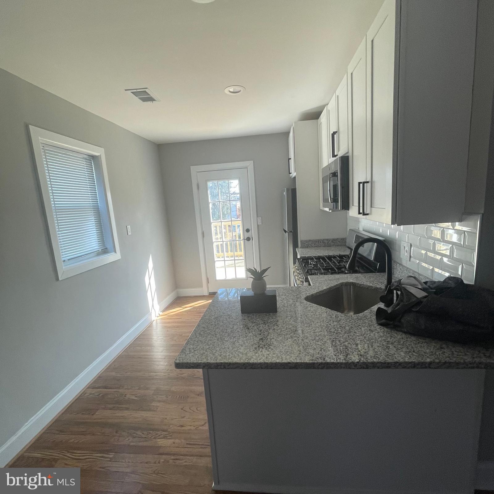 273 56th Place Northeast Washington, DC 20019 - Photo 10 of 25 a kitchen with granite countertop a sink a stove and granite counter tops