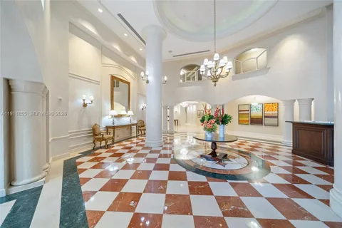 a living room with a dining table and a chandelier