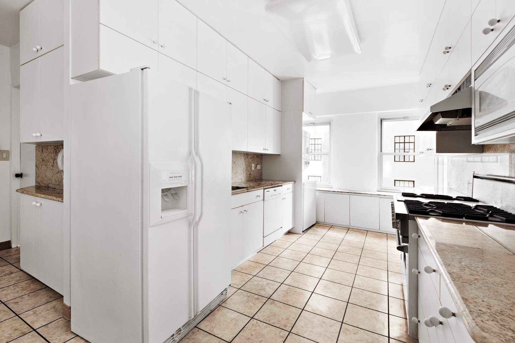 857 5th Avenue, Unit 7 Manhattan, NY 10065 - Photo 21 of 22 a kitchen with stainless steel appliances granite countertop a refrigerator and a stove