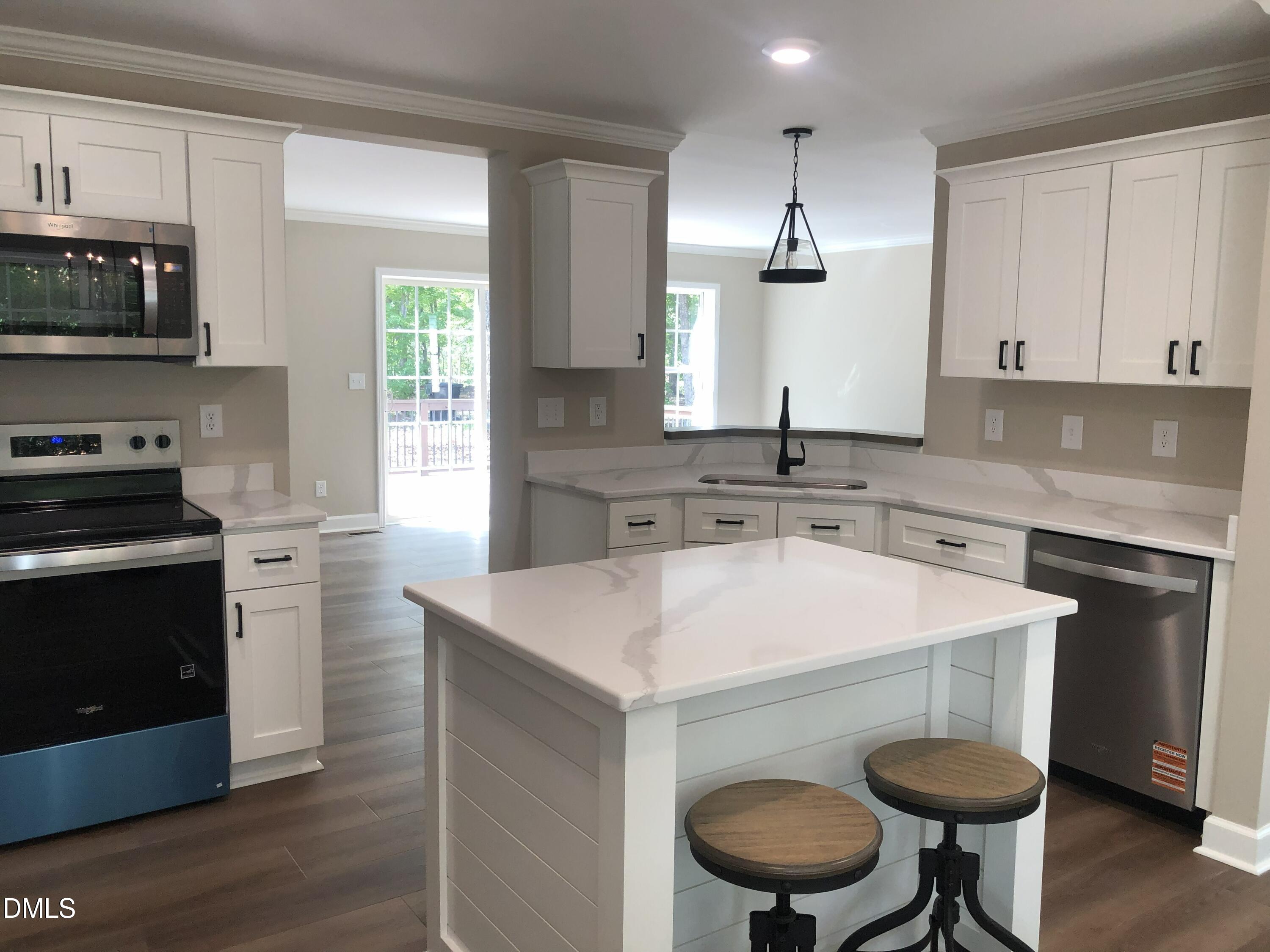 95 Smith Taylor Trail Roxboro, NC 27574 - Photo 4 of 47 a kitchen with stainless steel appliances granite countertop a sink a stove a refrigerator a microwave oven with white cabinets and wooden floor