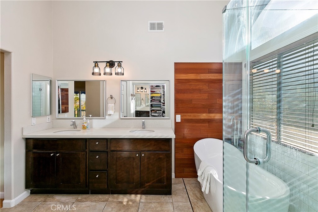 747 Donatello Drive Corona, CA 92882 - Photo 33 of 56 a bathroom with a granite countertop sink a mirror and shower