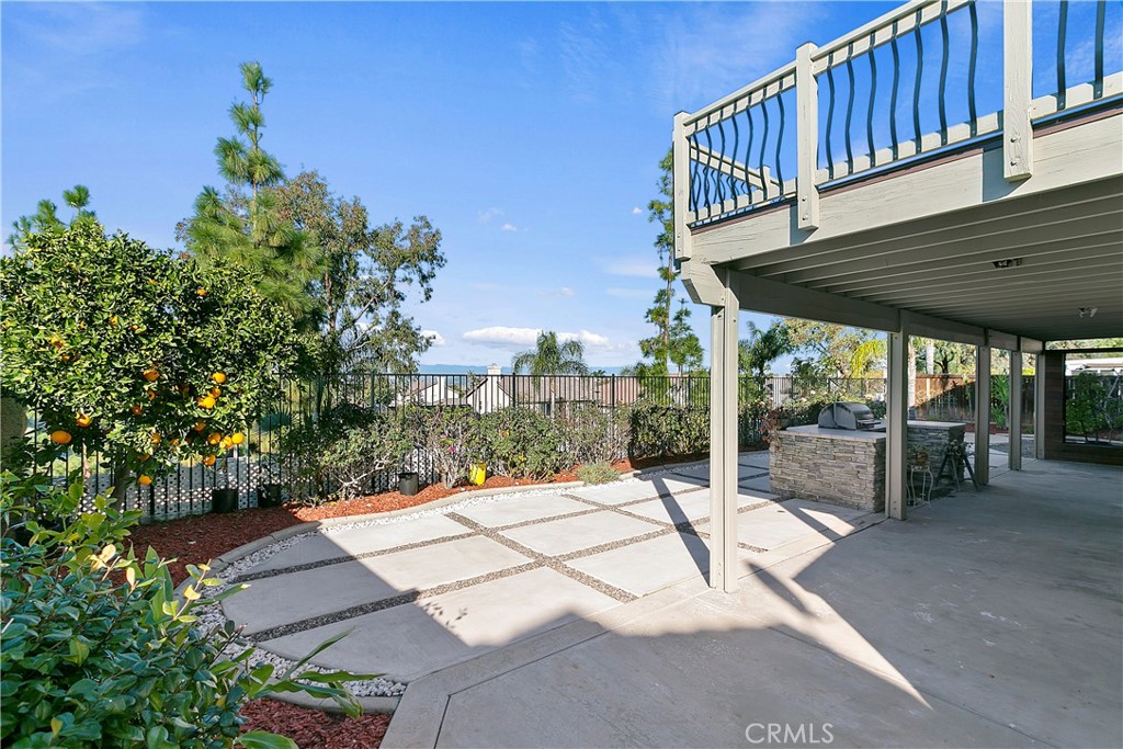 747 Donatello Drive Corona, CA 92882 - Photo 51 of 56 a view of a patio with a table and chairs under an umbrella with wooden floor and fence