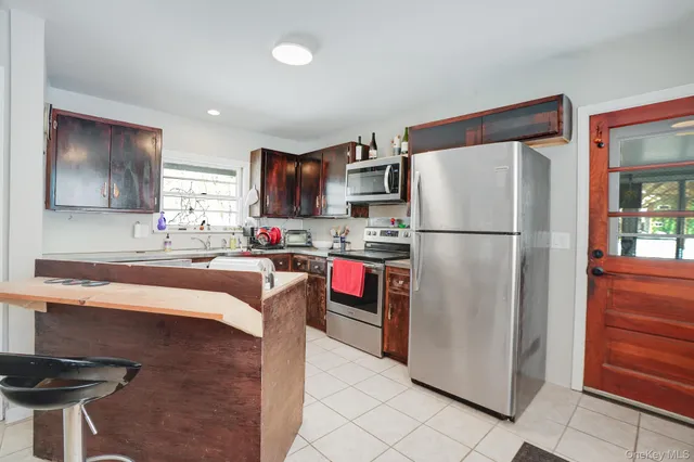 a kitchen with stainless steel appliances granite countertop a refrigerator a stove a sink and a microwave