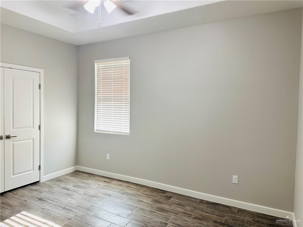 1101 Sugar Gdn Drive, Unit 1 Pharr, TX 78577 - Photo 8 of 10 an empty room with wooden floor and windows