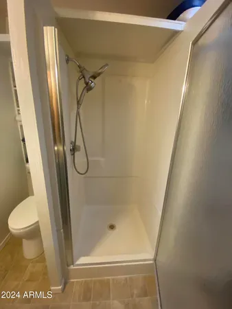 a bathroom with a glass door shower and toilet