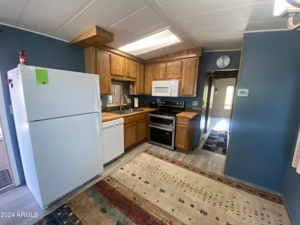 a kitchen with stainless steel appliances granite countertop a refrigerator a stove a sink and a microwave