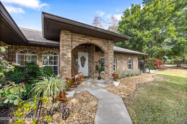 a front view of a house with a garden