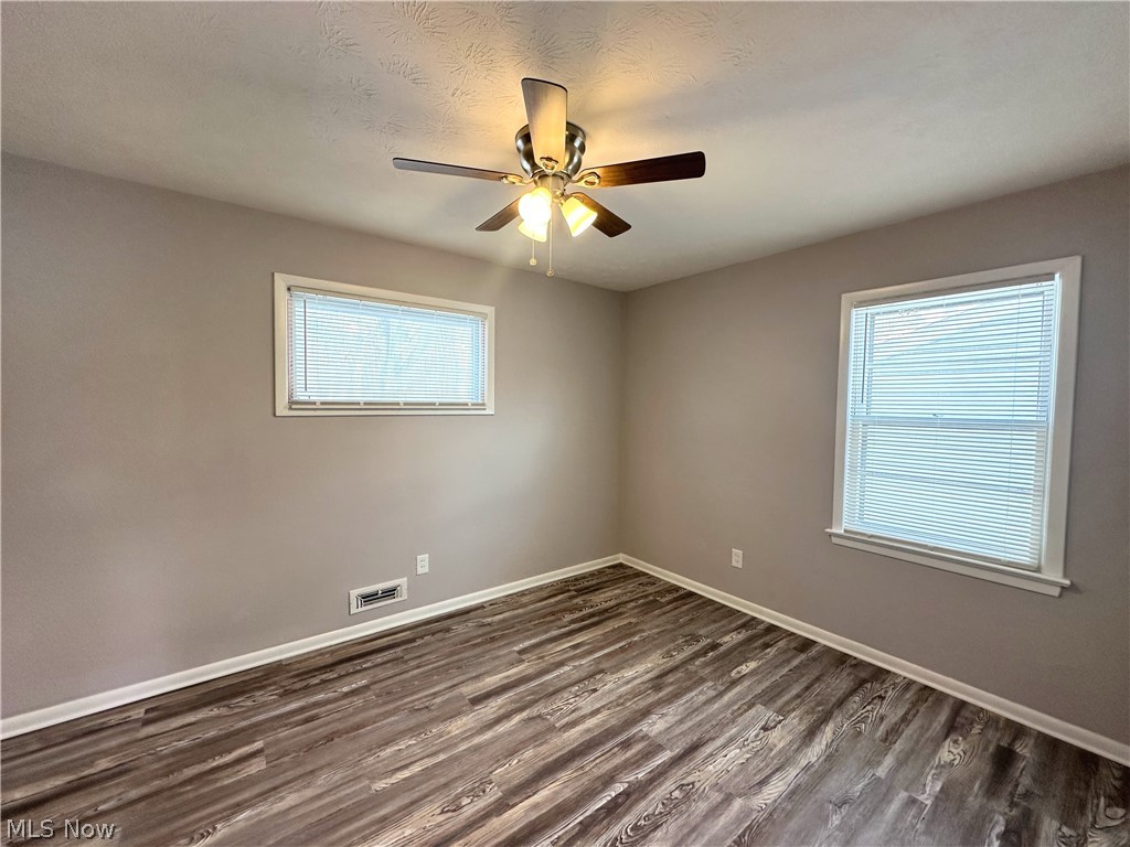 2440 Dentzler Road Parma, OH 44134 - Photo 6 of 11 Empty room featuring dark wood-style flooring and a ceiling fan
