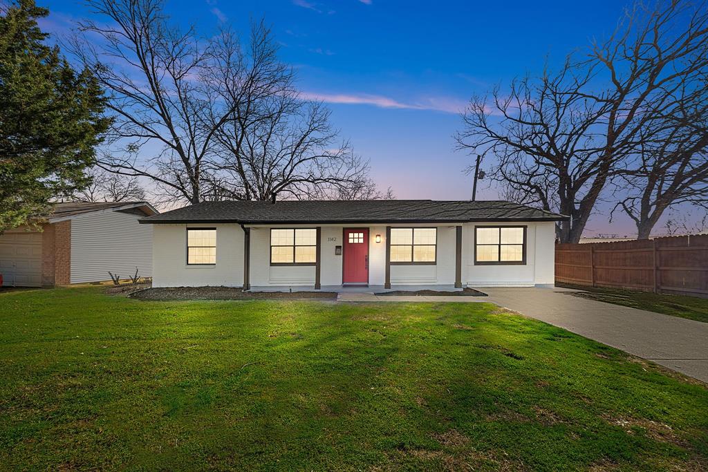 a large building with a big yard and large trees