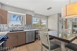 a kitchen with stainless steel appliances granite countertop a stove a refrigerator a kitchen island a table and chairs