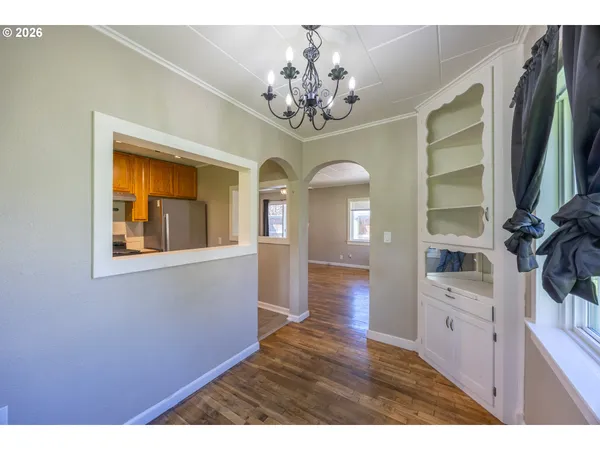 a view of a hallway with wooden floor and chandelier