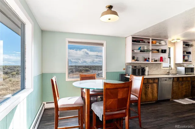 a kitchen with stainless steel appliances a refrigerator and a wooden floor