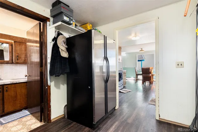 a kitchen with granite countertop a stove top oven a sink dishwasher a dining table and chairs with wooden floors