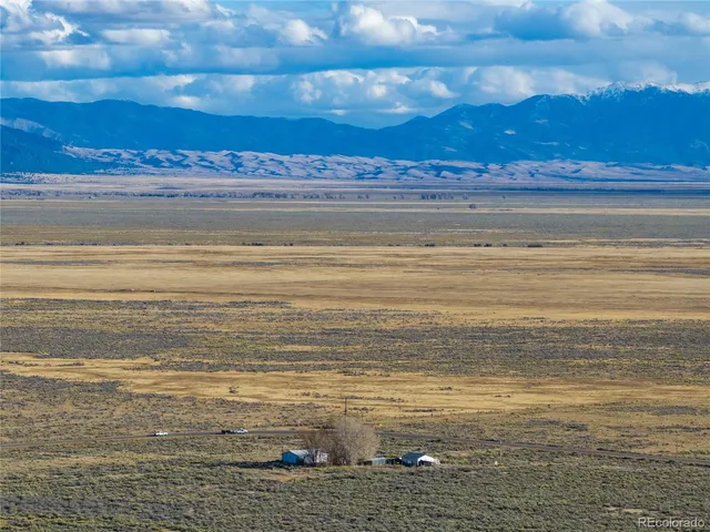 a view of backyard with a table and chairs and potted plants