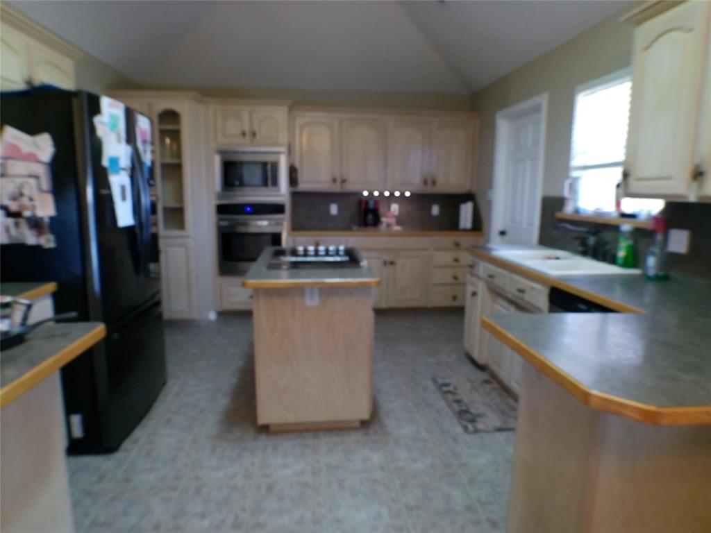 200 County Road 3170 Decatur, TX 76234 - Photo 19 of 31 a kitchen with stainless steel appliances granite countertop a refrigerator a stove top oven a sink and dishwasher