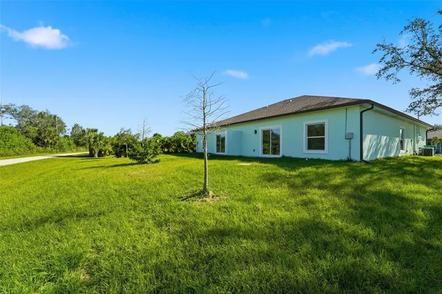 a house is sitting in middle od the grass