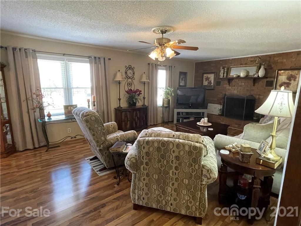 180 Watergate Drive Alexis, NC 28006 - Photo 16 of 40 a living room with furniture a fireplace and a flat screen tv
