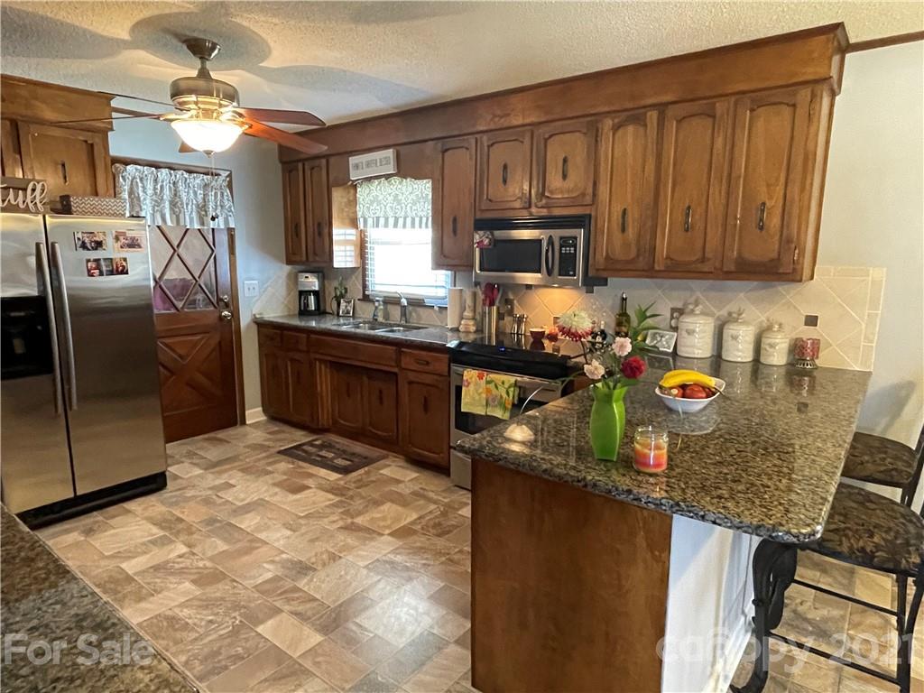 180 Watergate Drive Alexis, NC 28006 - Photo 20 of 40 a kitchen with stainless steel appliances granite countertop a sink stove and refrigerator