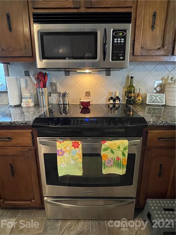 180 Watergate Drive Alexis, NC 28006 - Photo 21 of 40 a kitchen with stainless steel appliances granite countertop a stove and a microwave